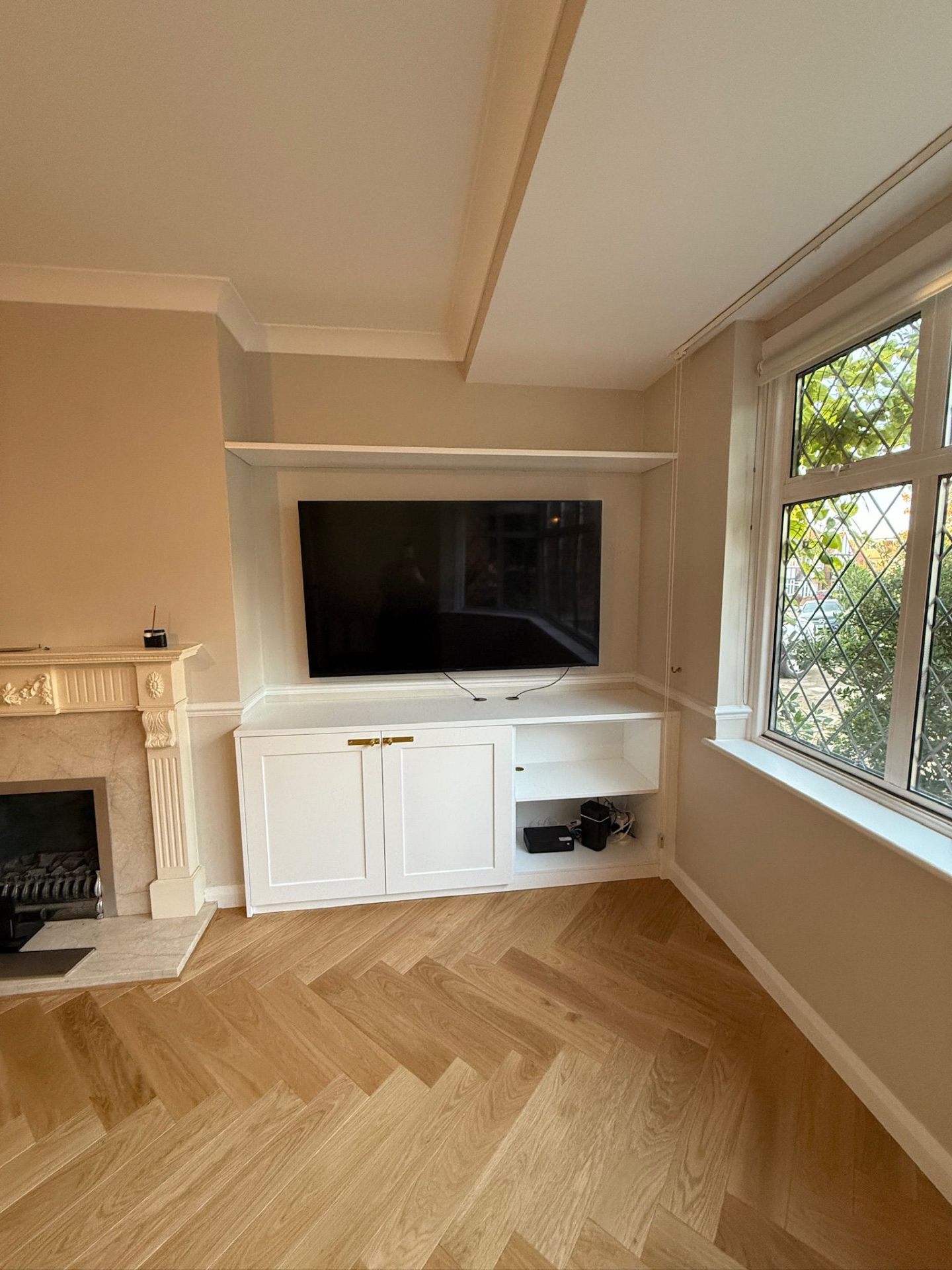 Alcove cabinets flanking a fireplace with wall-mounted TV above