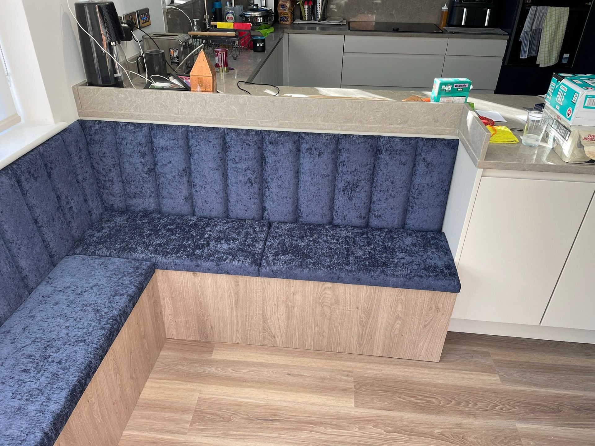 Corner banquette with blue velvet upholstery and oak base