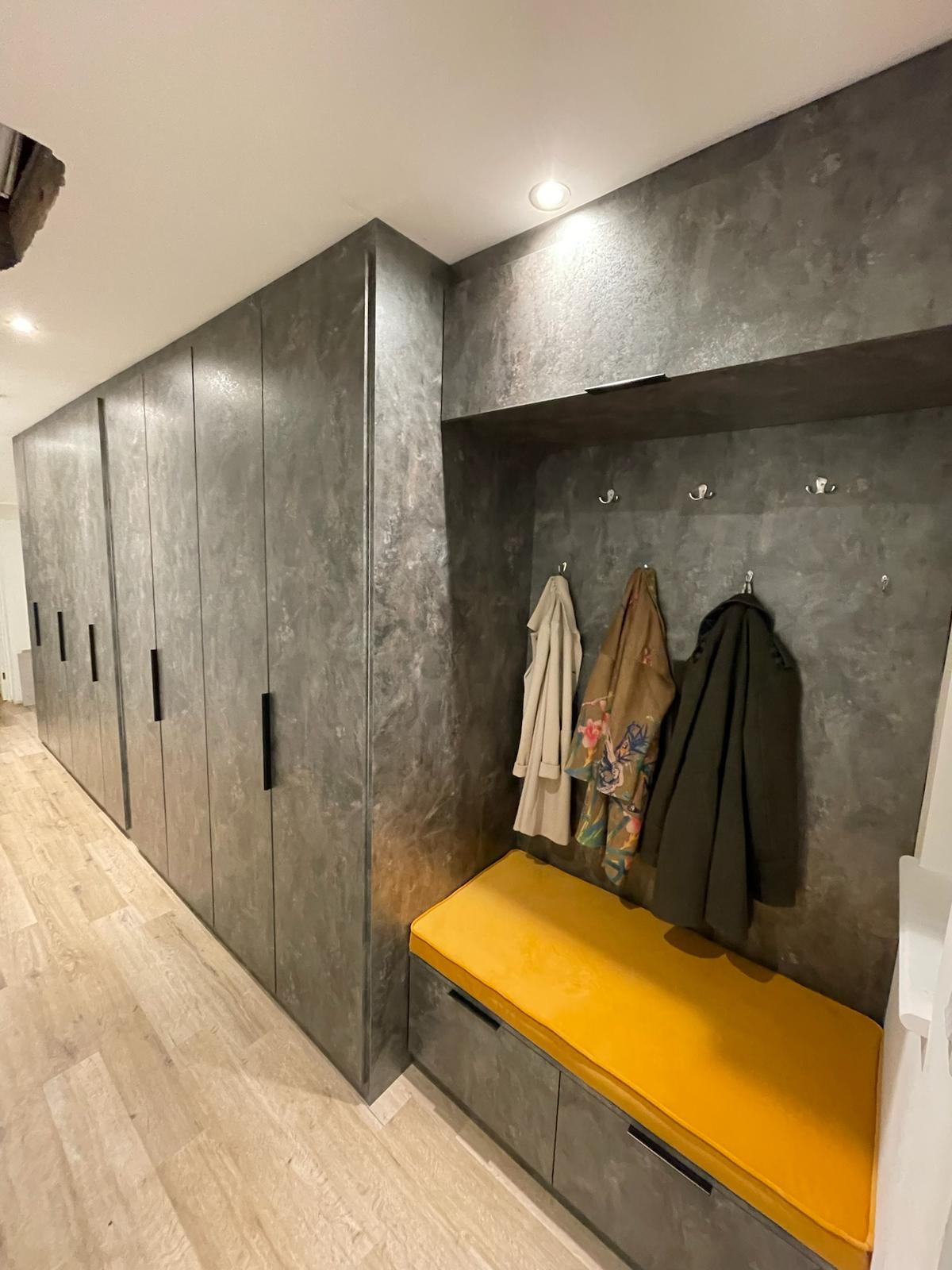 Fitted hallway bench with yellow cushion and coat storage