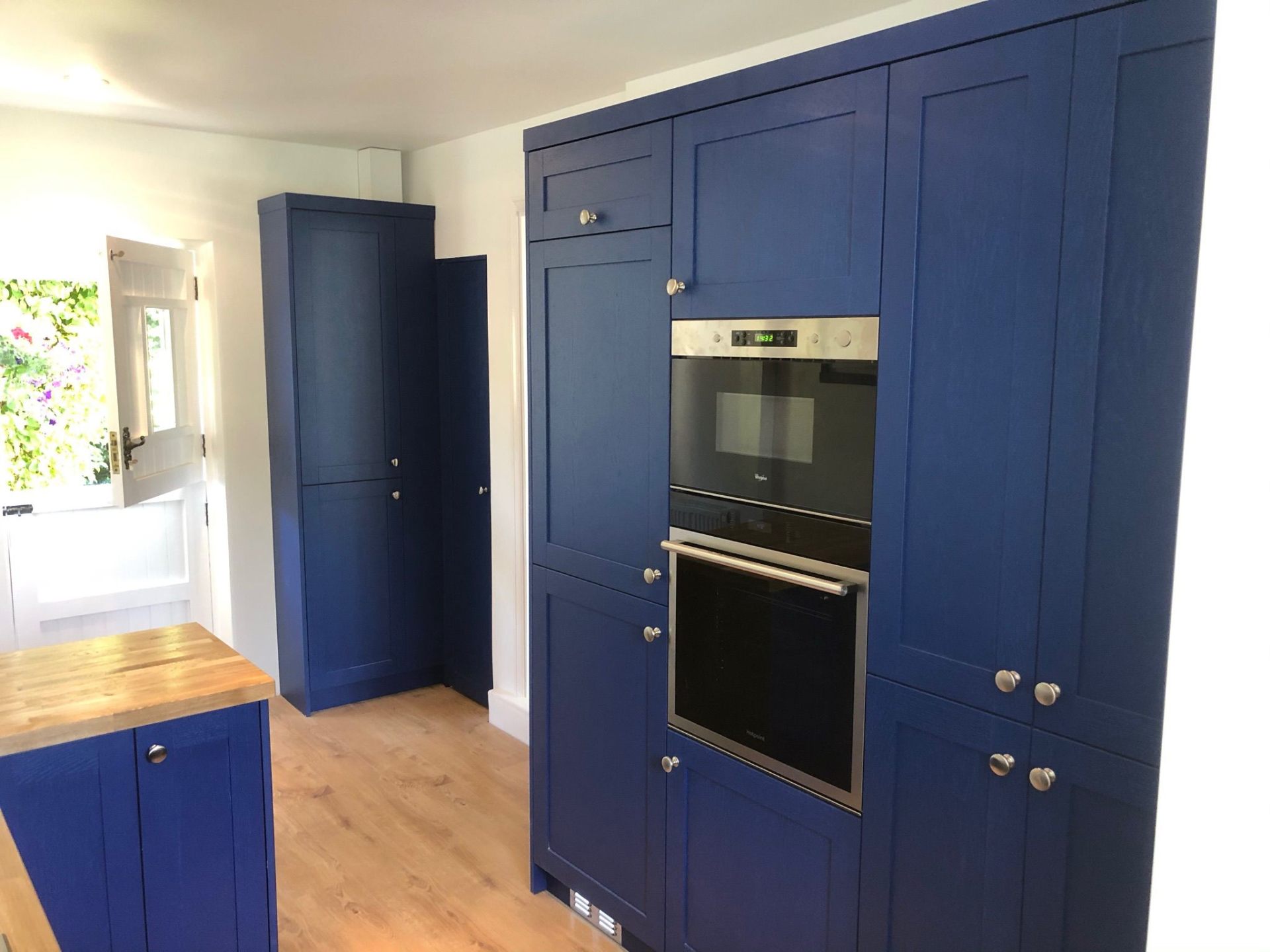 Navy blue tall kitchen larder unit with solid oak worktop