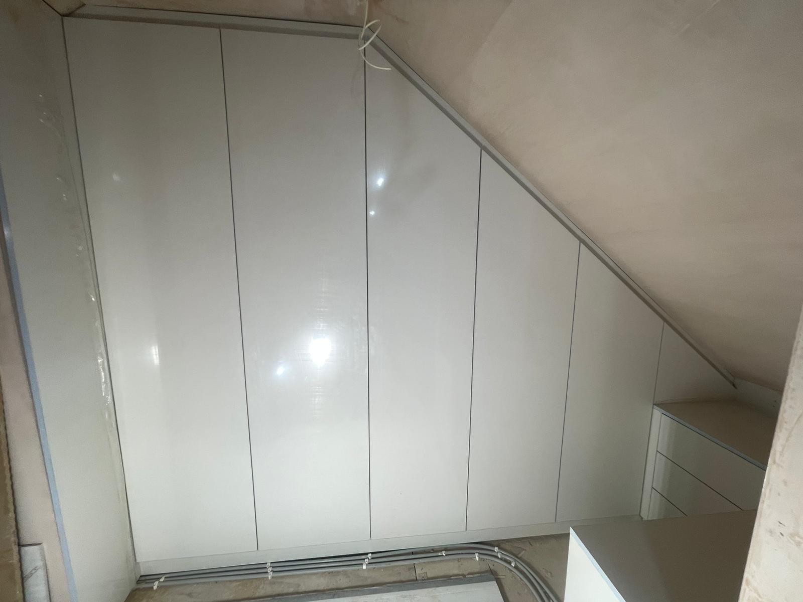 Angled fitted wardrobe following the roofline of a loft conversion