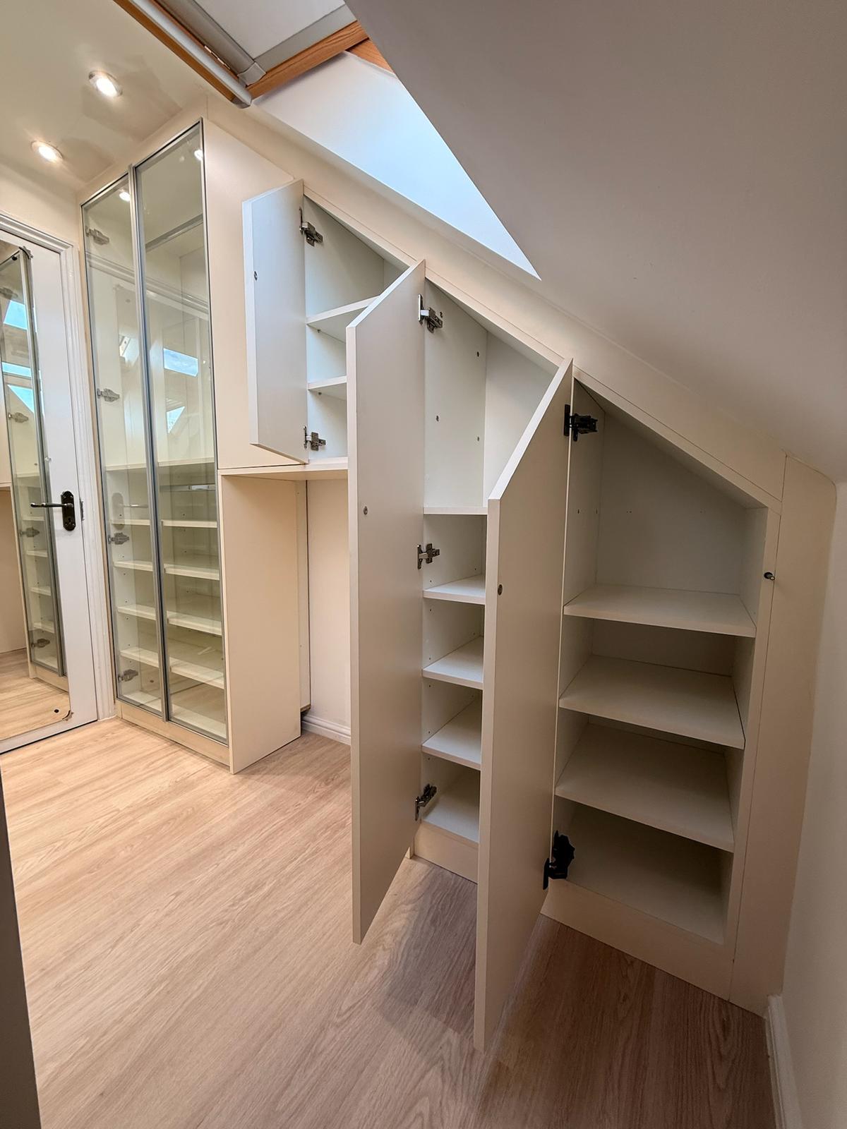 Loft eaves storage with doors open showing adjustable shelving inside