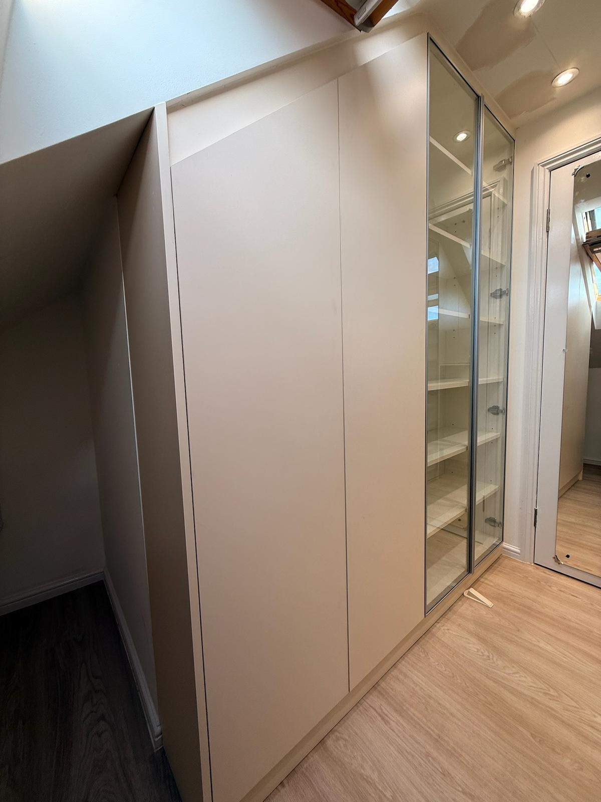 Loft wardrobe with glass display doors and angled panel sections