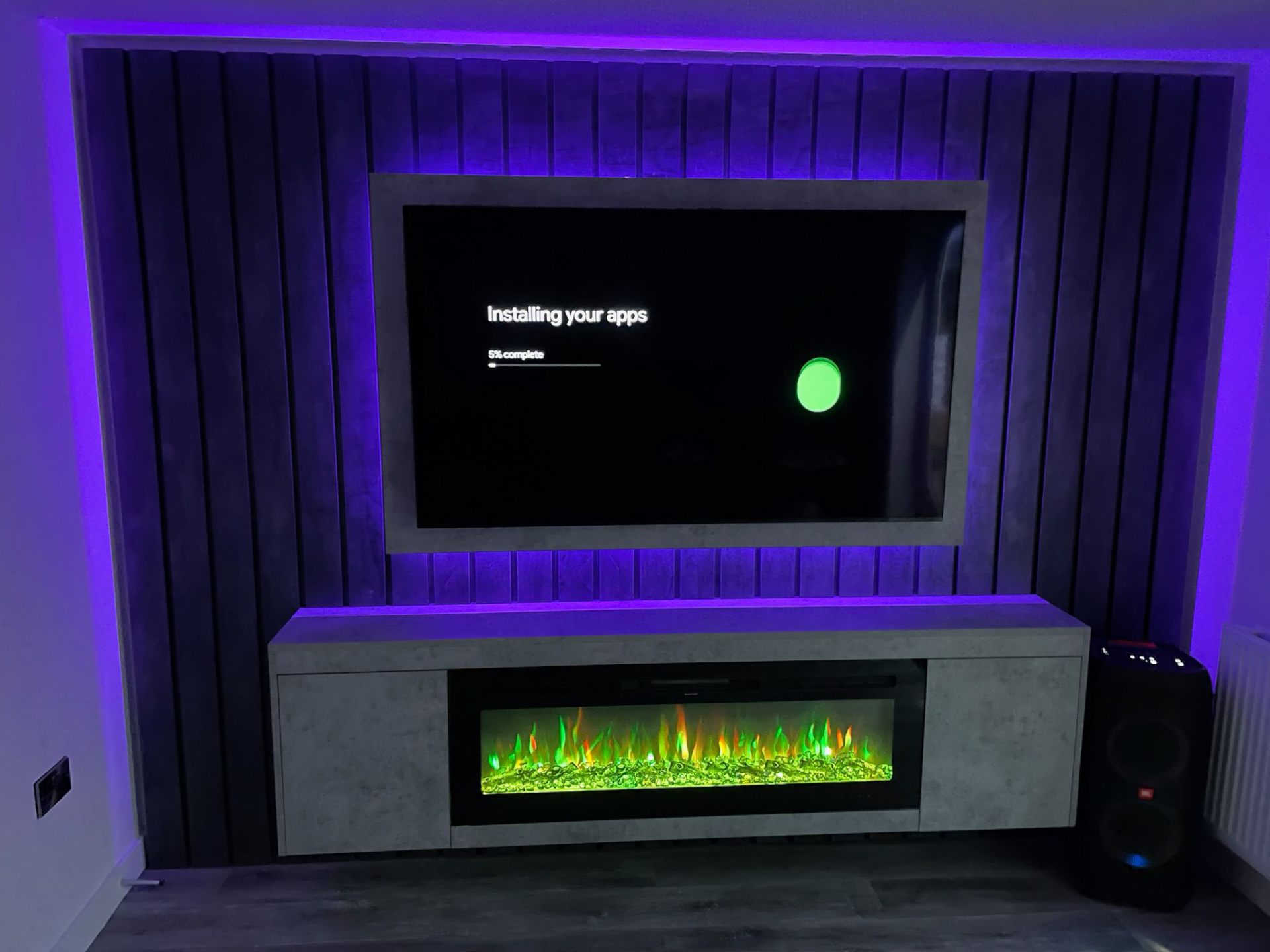 Media wall with purple LED backlighting and floating shelf