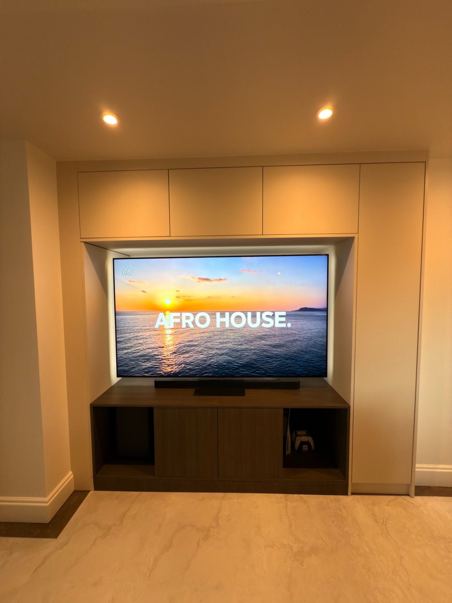 Recessed media wall with concealed storage and integrated lighting