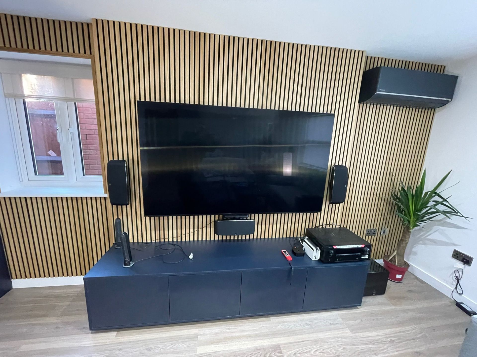 Media wall with oak slat cladding and wall-mounted TV — doors closed