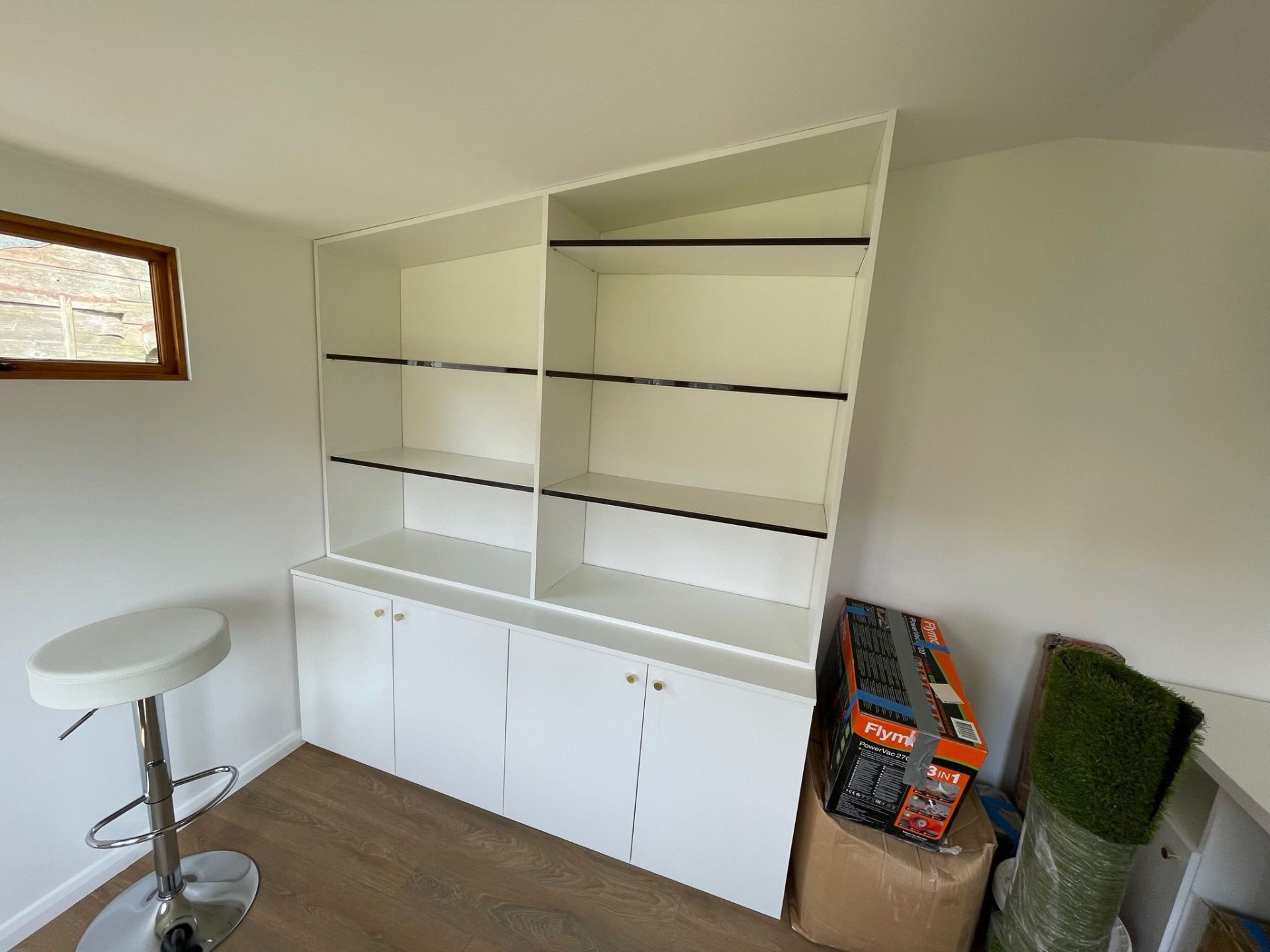 White display shelving unit with lower cupboards in a home office