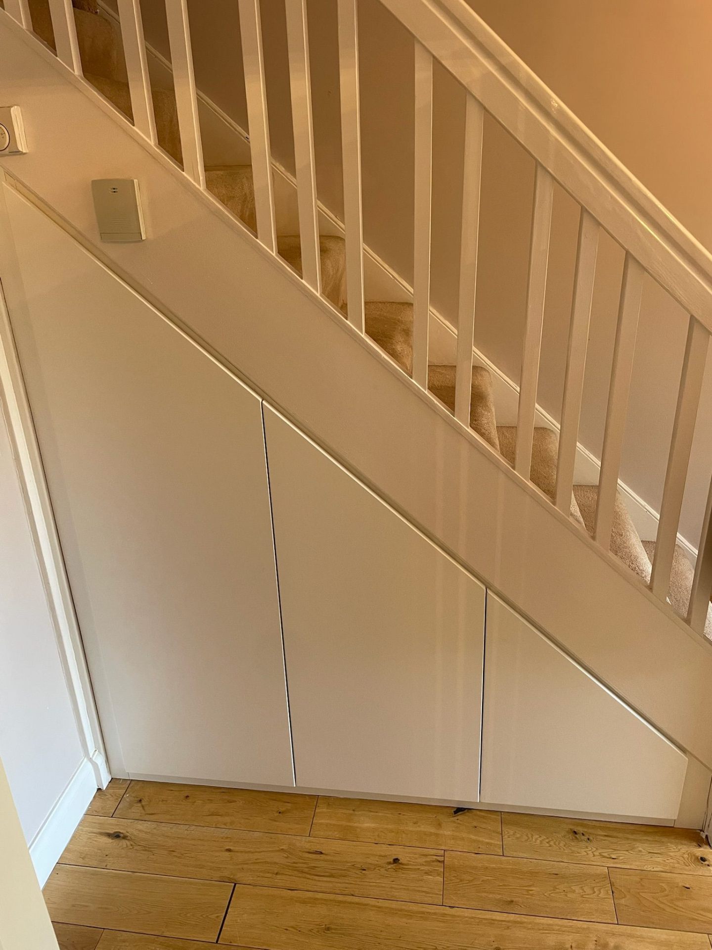 Cream under-stairs cupboard fitted into a period hallway