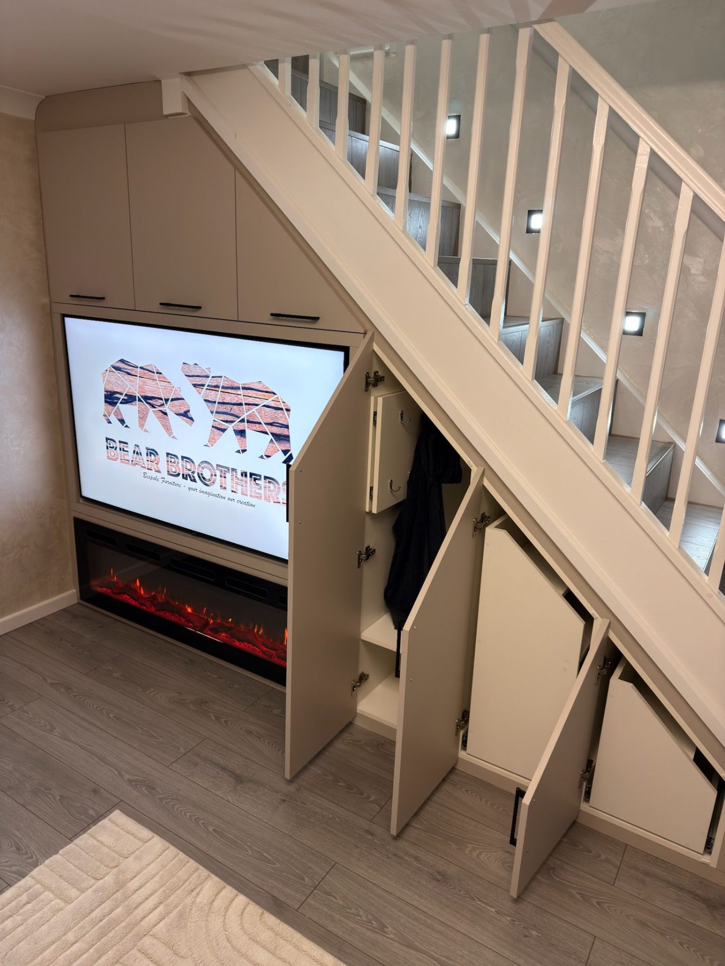Under-stairs unit with doors open showing TV recess and hidden storage