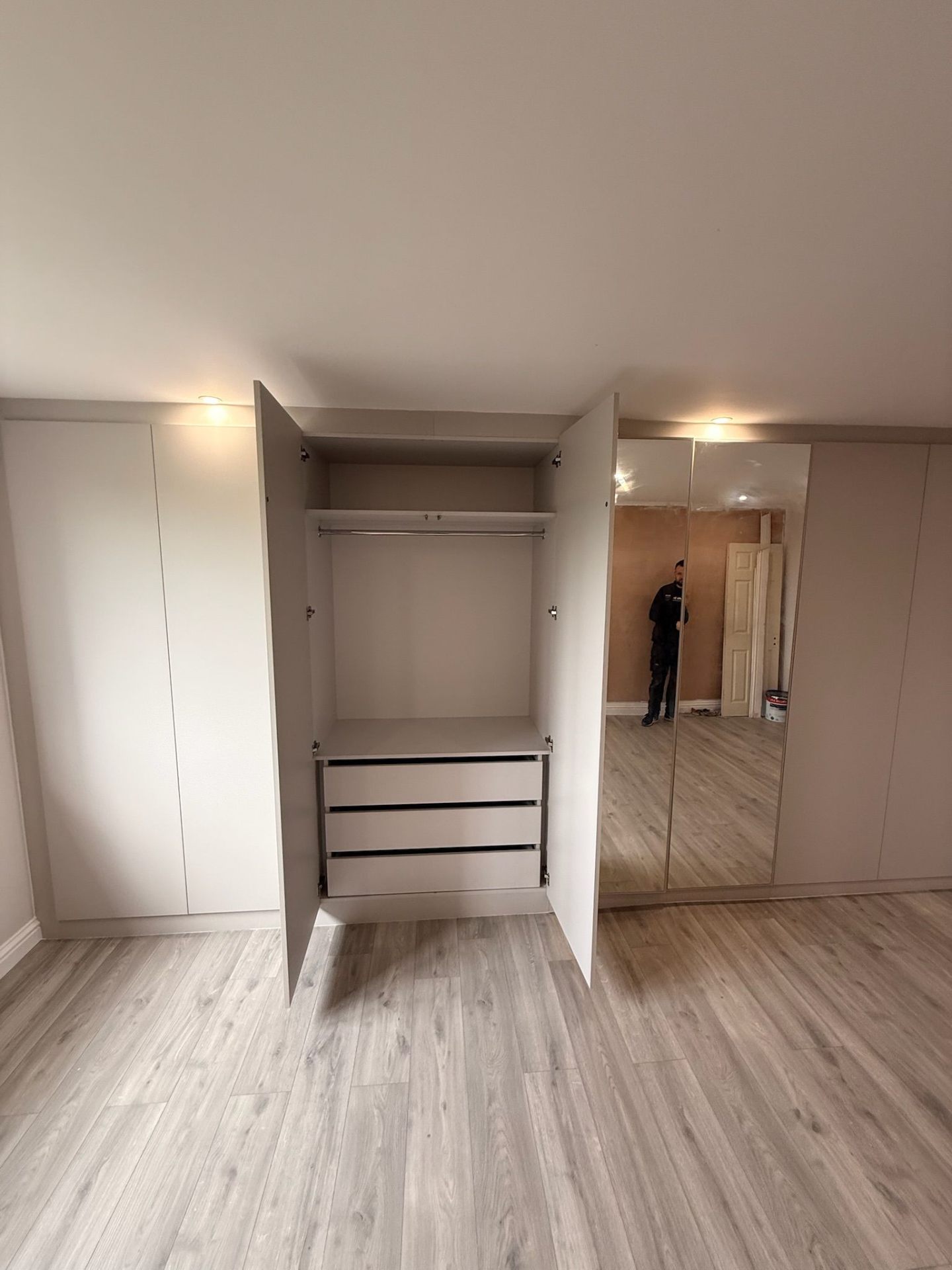 Fitted wardrobe open showing hanging rail and internal drawers