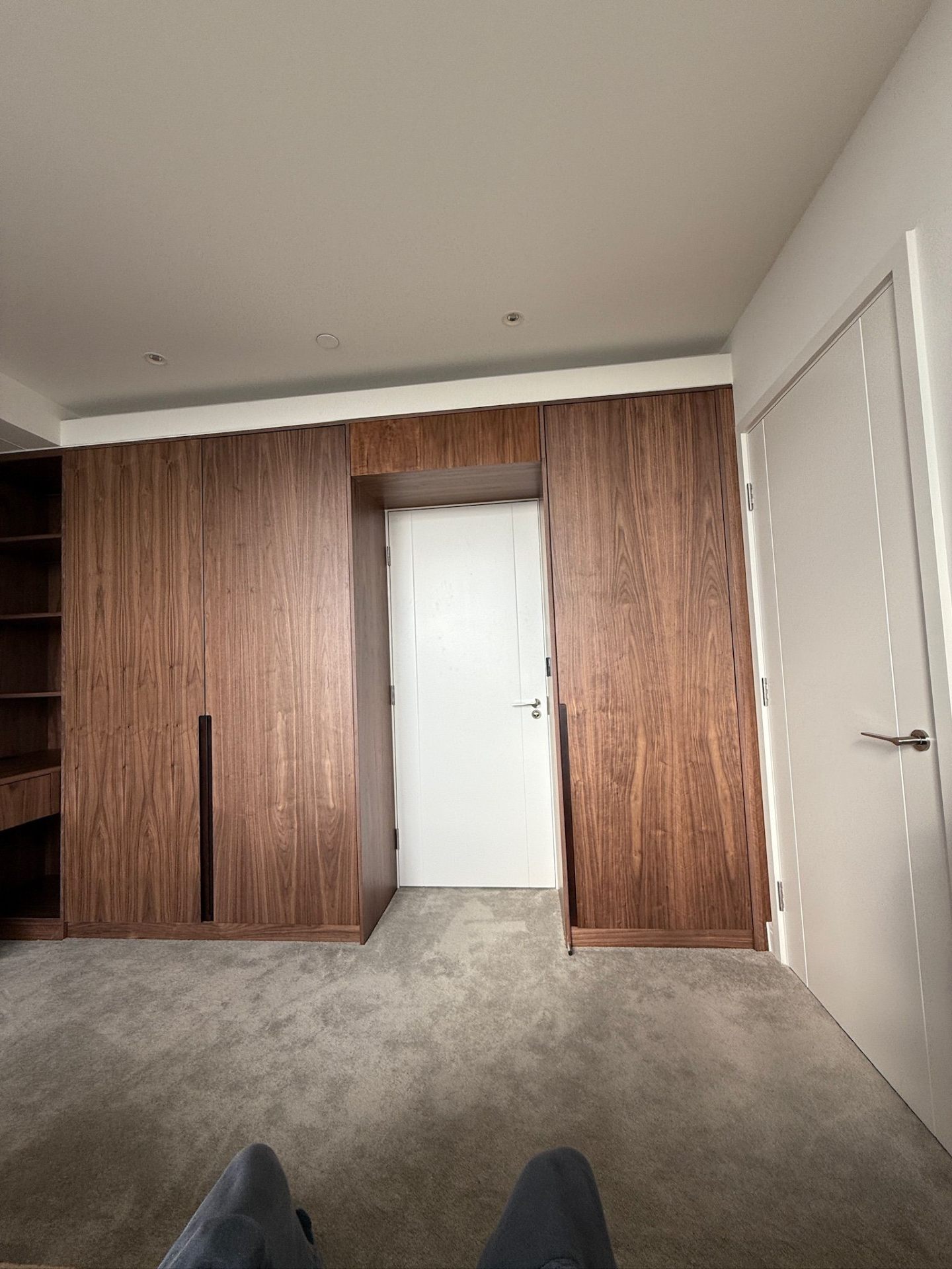 Close-up of walnut fitted wardrobe door with modern handle